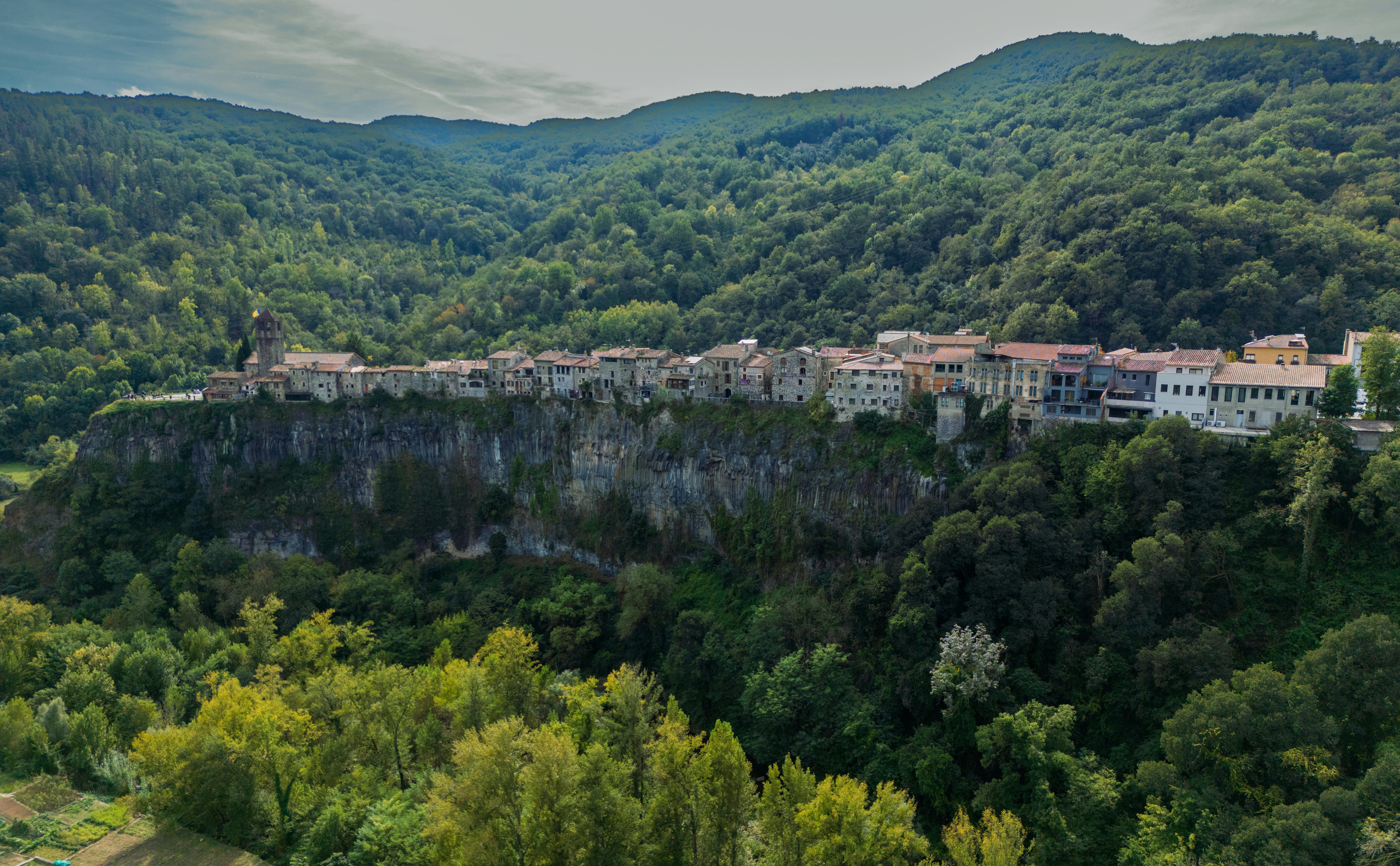 Breathtaking aerial view of Castellfollit de la Roca, a picturesque village perched on a cliff in Spain's Catalonia region.